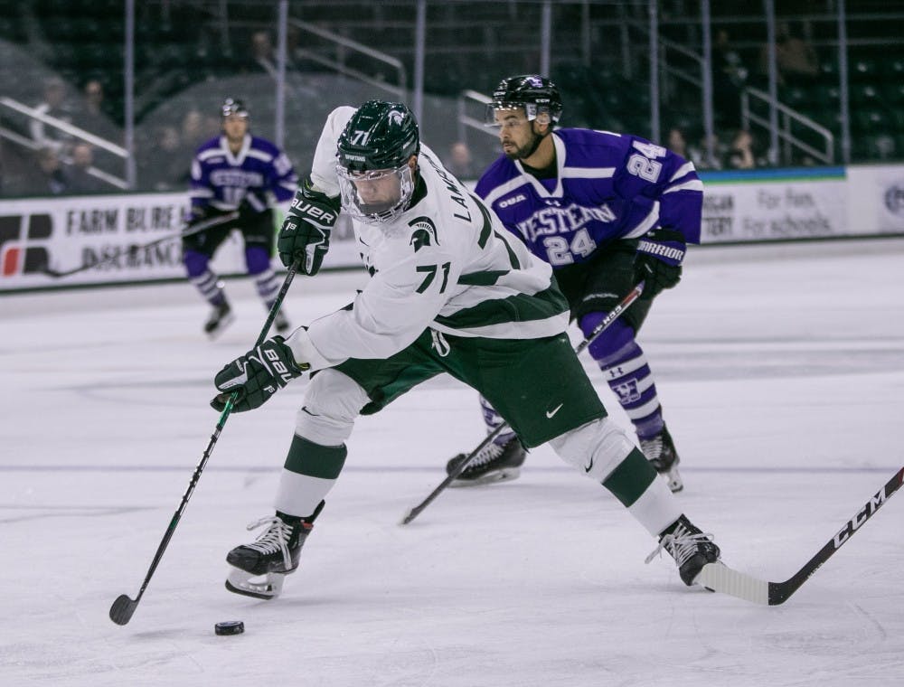 <p>Senior forward Logan Lambdin (71) takes the puck up the ice during the game against Western Ontario at Munn Ice Arena Oct. 7, 2019. The Spartans defeated the Mustangs, 6-1.</p>