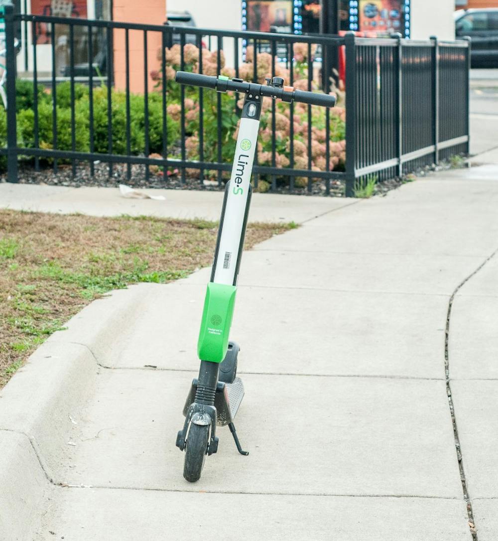 <p>A Lime scooter is pictured parked on the sidewalk on Grand River Avenue.</p>