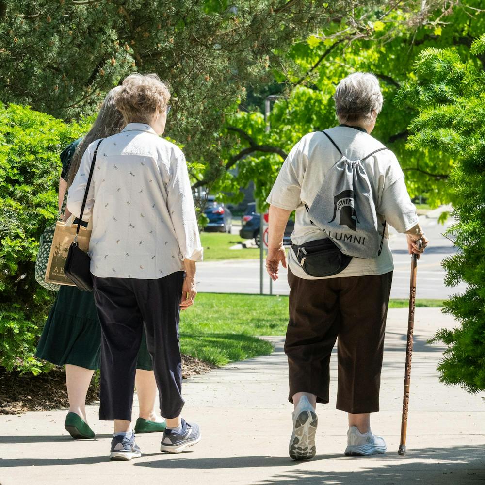 <p>Three MSU alumni walk on the path near Beaumont Tower during a Spartan Reunion in East Lansing, Mich., on May 28, 2026.</p>