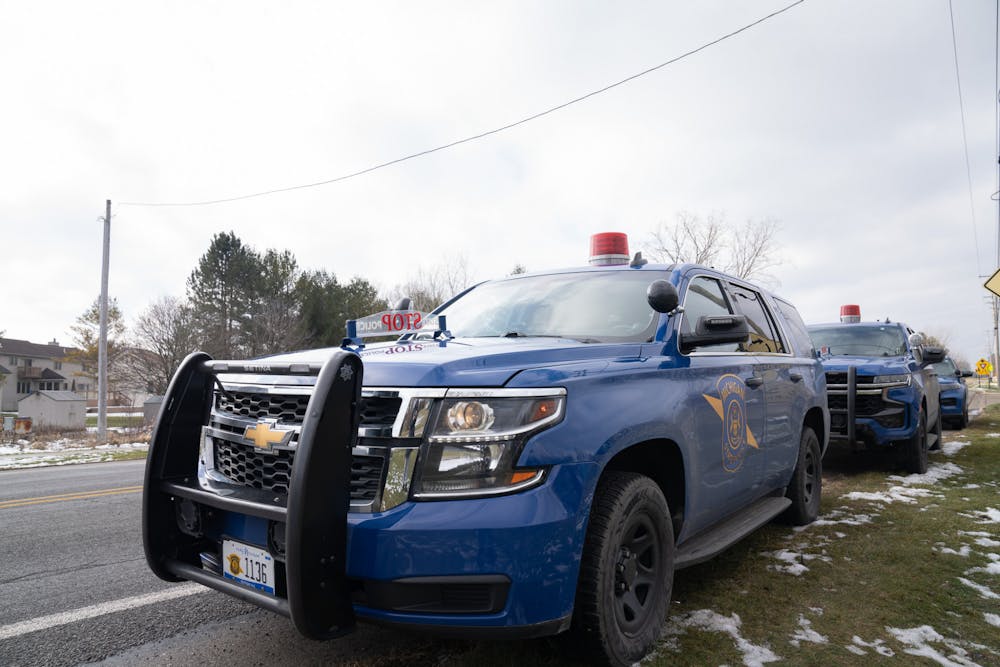 <p>Michigan State Police cop cars line the streets at the 242 Community Church in Okemos after a false shooting report at Okemos High School on Feb. 7, 2023.</p>