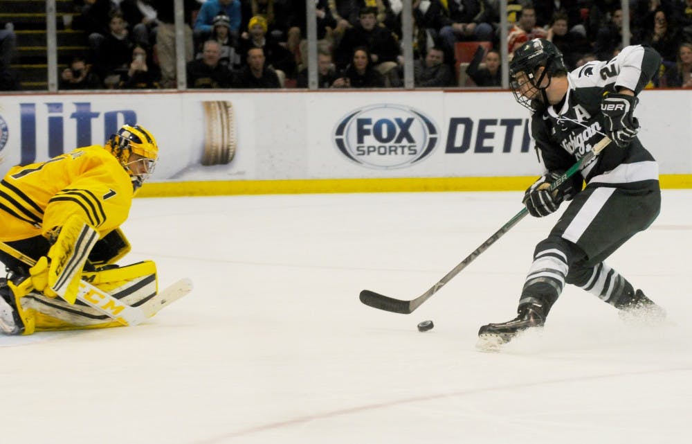 Junior right wing Joe Cox scores a penalty shot against Michigan goaltender Steve Racine during the second period of the game against Michigan on Feb. 5, 2016 at Joe Louis Arena. The Spartans defeated the Wolverines, 3-2.