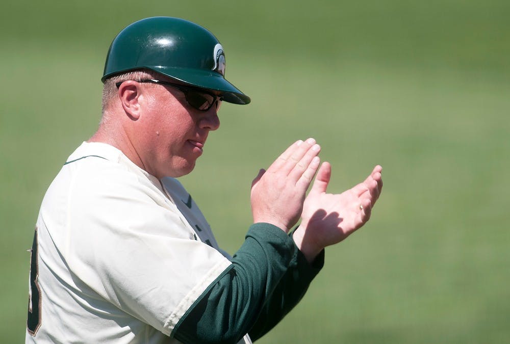 <p>Men's baseball coach Jake Boss Jr. encourages players from third base in the third game of the series against the University of Illinois on May 5, 2013, at McLane Baseball Stadium at Old College Field. The Spartans won 4-3 after trailing 3-1 for a majority of the game. Danyelle Morrow/The State News</p>
