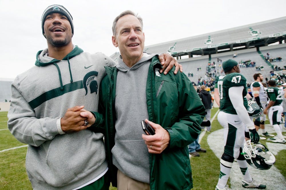 Head coach Mark Dantonio greets former Spartan player Devin Thomas, on Saturday afternoon at Spartan Stadium after the conclusion of the annual Spring Game. Thomas announced his retirement from the Chicago Bears on August 5, 2012. State News File Photo