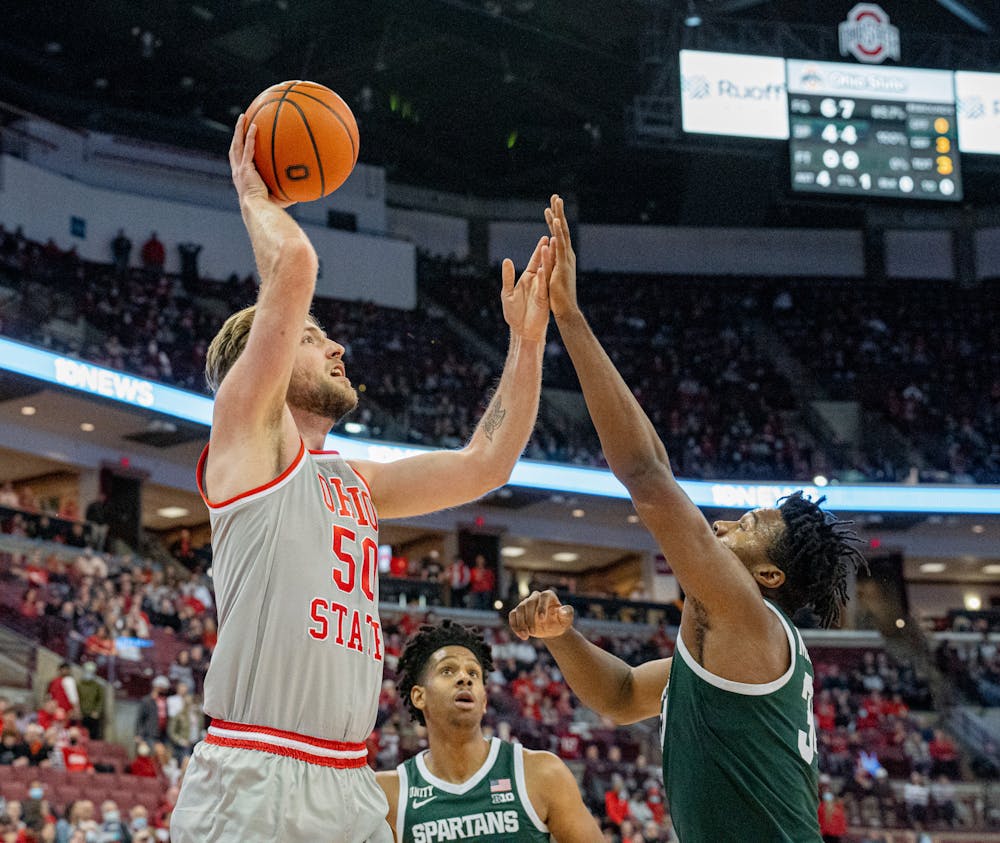 <p>Graduate student center Joey Brunk shoots over junior forward Julius Marble II during the Buckeye&#x27;s 80-69 win over the Spartans on Mar. 3, 2022.</p>