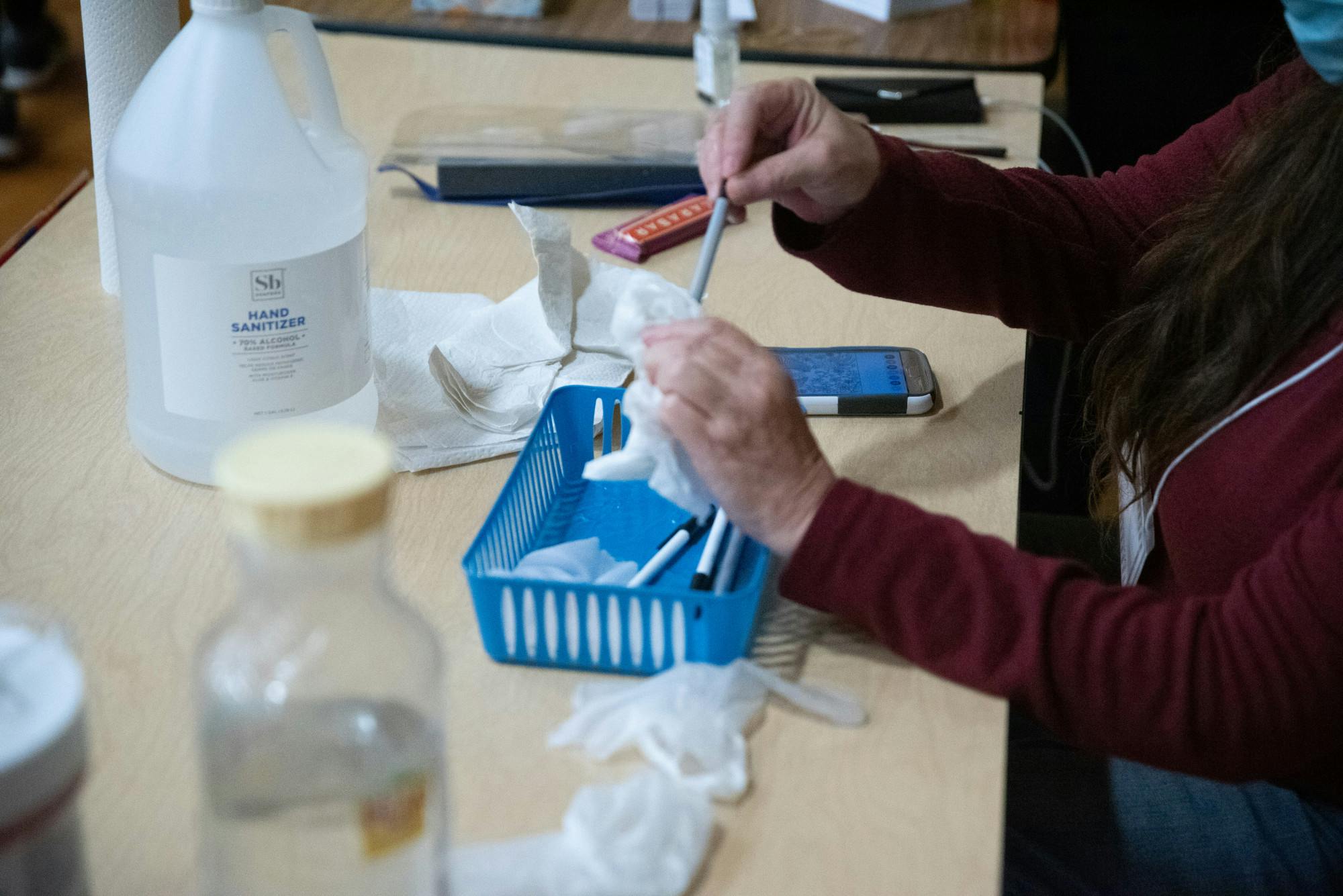 A person sanitizes pens at a polling location.