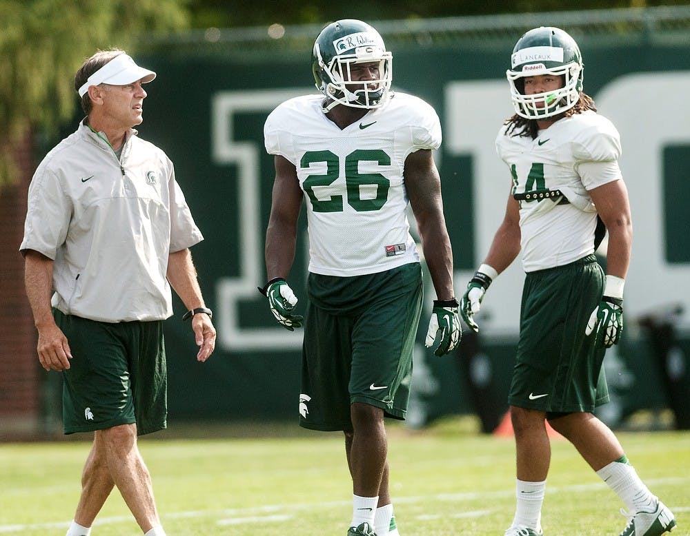 <p>From left, head coach Mark Dantonio, junior safety RJ Williamson, and junior safety Chris Laneaux participate in practice drills Aug. 8, 2014, at the practice field outside Duffy Daugherty Football Building. The football season kicks off on Aug. 29, with a game against Jacksonville State. Jessalyn Tamez/The State News</p>