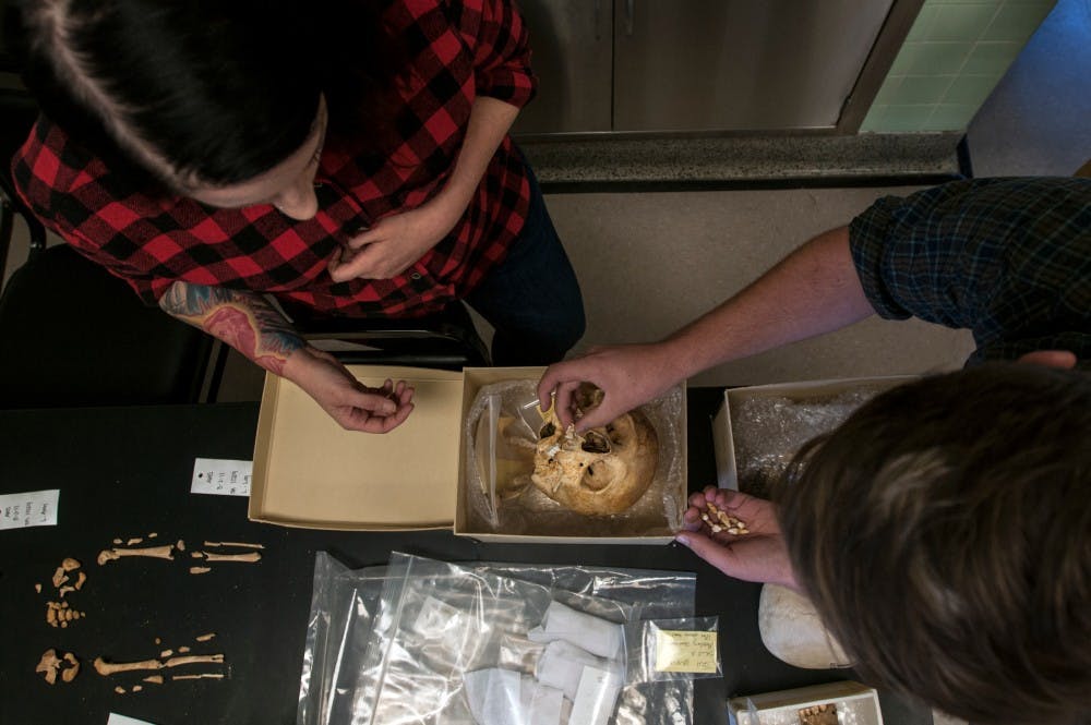 Graduate student Jack Biggs, right, assembles skeletal remains alongside MSU physical anthropology professor Amy Michael on Sept. 26, 2016 in the Maya bioarchaeology lab at Giltner Hall. Remains from Belize are collected every two years and brought to the lab for various experimentation. 