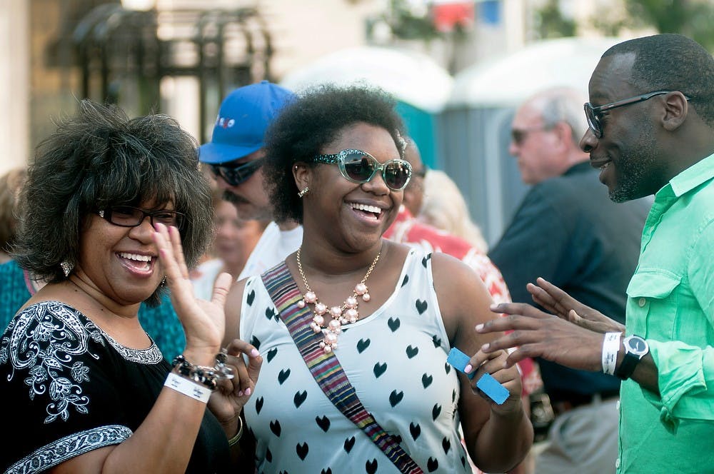 	<p>From left, Lansing residents Sonya Lang, Joy Lang, and Alvin Holloway, laugh after running into each other at the Taste of Downtown on July 20, 2013, on S. Washington Square in downtown Lansing. Holloway, a co-worker of Sonya Lang, was an old acquaintance and surprised his two friends. Danyelle Morrow/The State News</p>