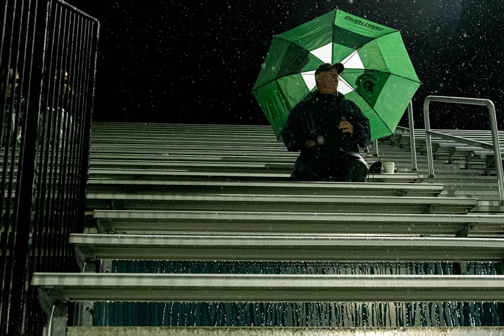 <p>A fan sits through the rain to watch the end of the game. Michigan State men&#x27;s soccer team defeated Duquesne 1-0 on Sept. 21, 2021 in East Lansing.</p>