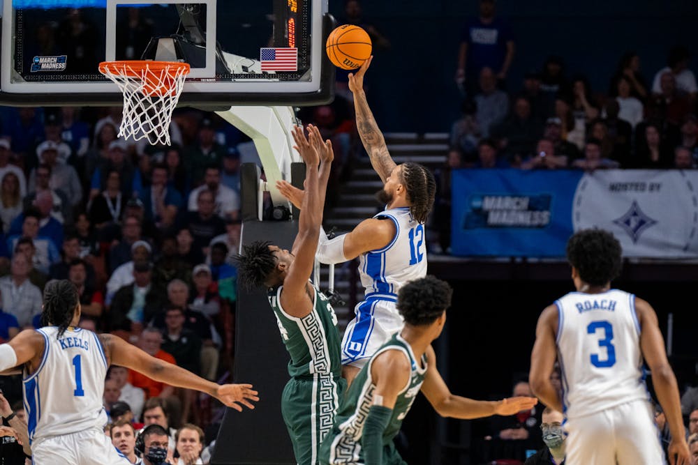 <p>Graduate student forward Theo John (12) shoots the ball during Duke&#x27;s victory over Michigan State on March 20, 2022.</p>