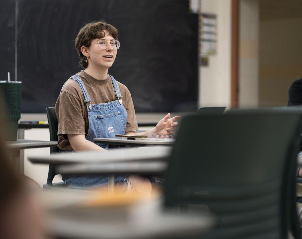 Sigma Tau Delta English Honors Society President and English senior Sydney Logsdon talks to attendees of the club's Banned Book Night at Wells Hall on April 21, 2025.