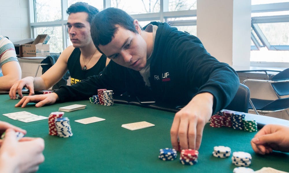 History education junior Jason Andrews counts chips during a poker club meeting on Feb. 19, 2015 in Erickson Hall. Members of the club meet weekly and play poker against one another, competing for points. 
