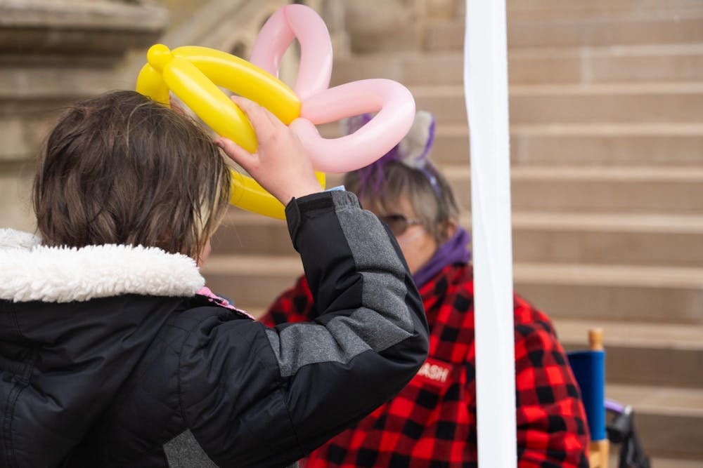 <p>A young girl tries out her balloon hat at an Easter egg hunt on the Capitol lawn in Lansing, MI, on Saturday, March 30, 2024. The event, hosted by JCI Lansing, gave families a chance to celebrate Easter outdoors despite drizzling rain.</p>
