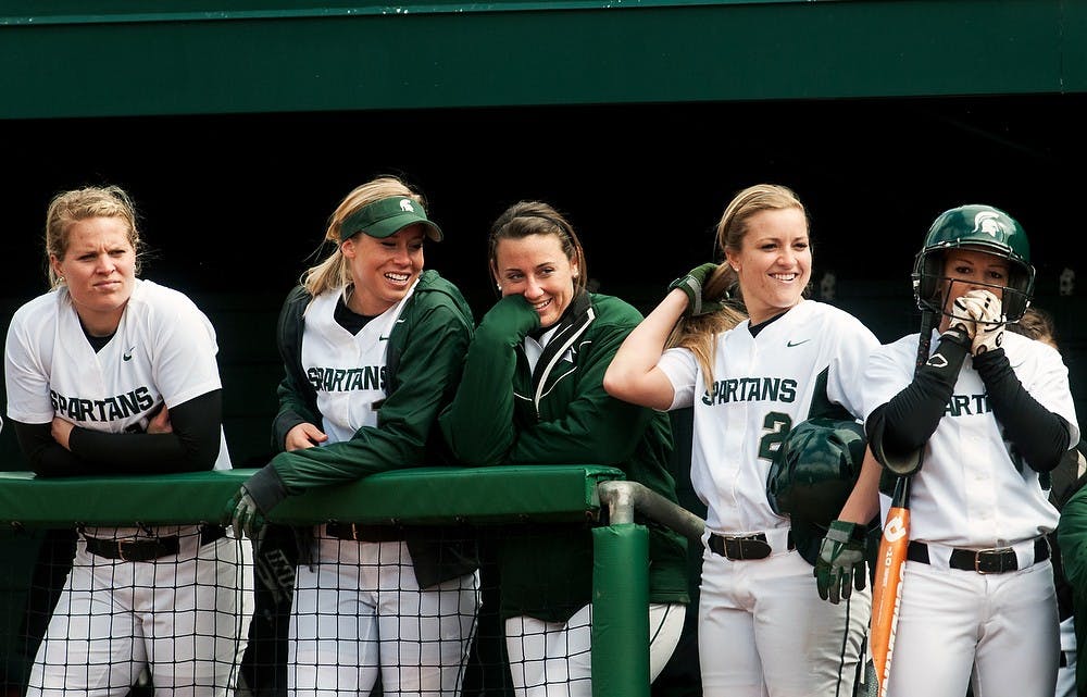 	<p>Members of the <span class="caps">MSU</span> softball team smile in the dugout at a player on the field during the game against Michigan, April 14, 2013, at Secchia Stadium at Old College Field. Katie Stiefel/The State News</p>
