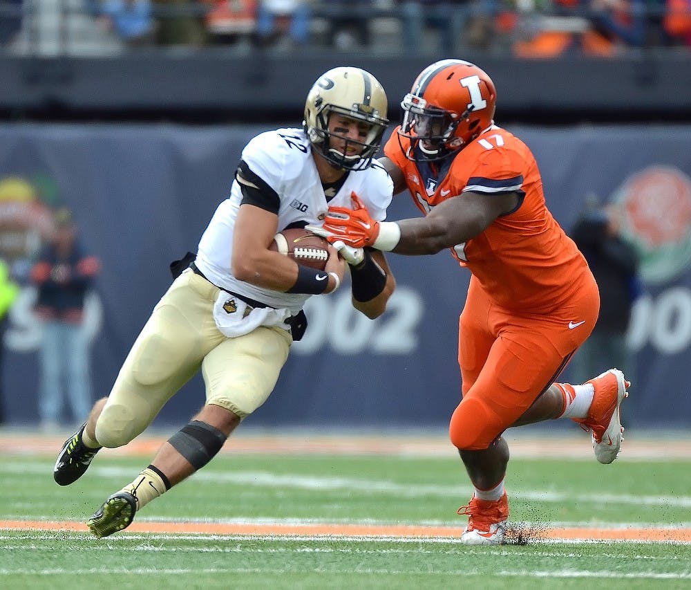 <p>Purdue sophomore quarterback Austin Appleby pushes through Illinois defensive lineman Jihad Ward on Saturday at the University of Illinois Memorial Stadium. Photo Courtesy of Purdue Exponent</p>