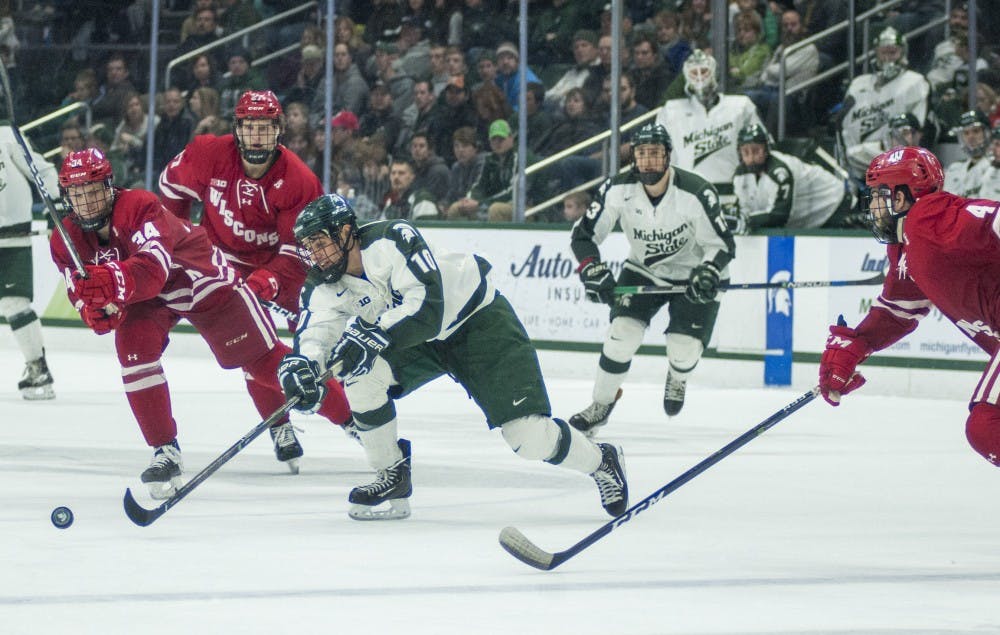 Freshman forward Sam Saliba (10) possesses the puck from Wisconsin forward Trent Frederic (34) during the third period of the men's hockey game against Wisconsin on Feb. 4, 2017 at Munn Ice Arena. The Spartans were defeated by the Badgers, 3-4.
