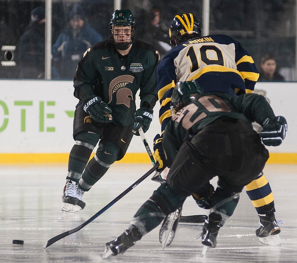 <p>Freshman defenseman Josh Jacobs and junior forward Michael Ferrantino defend Michigan forward Dylan Larkin Feb. 7, 2015, during the game against Michigan at Soldier Field in Chicago, Illinois.  The Spartans were defeated by the Wolverines, 4-1, in the Coyote Logistics Hockey City Classic. Alice Kole/The State News</p>