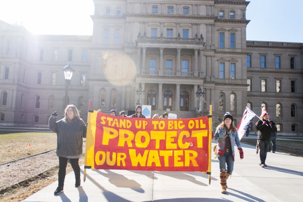 Protestors march with a sign from Standing Rock during the World Water Day rally on March 22, 2017 at Capitol in Lansing. "Mni Wiconi! Water is Life!" the protestors yelled.
