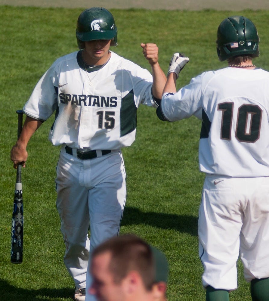 	<p>Sophomore centerfielder Anthony Cheky bumps fists with sophomore short stop Ryan Richardson after a run on May 8, 2013, at McLane Baseball Stadium at Old College Field. The Spartans beat Eastern Michigan 6-3. Danyelle Morrow/The State News</p>