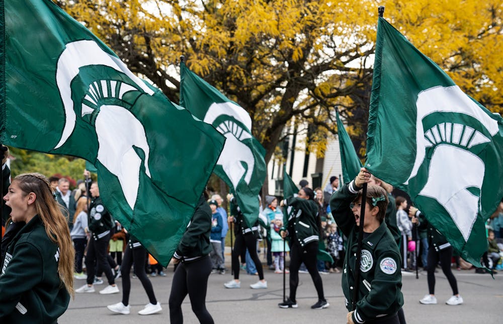 Members of the MSU Color Guard wave their Spartan flags at the MSU Homecoming Parade on Oct. 14, 2022. 