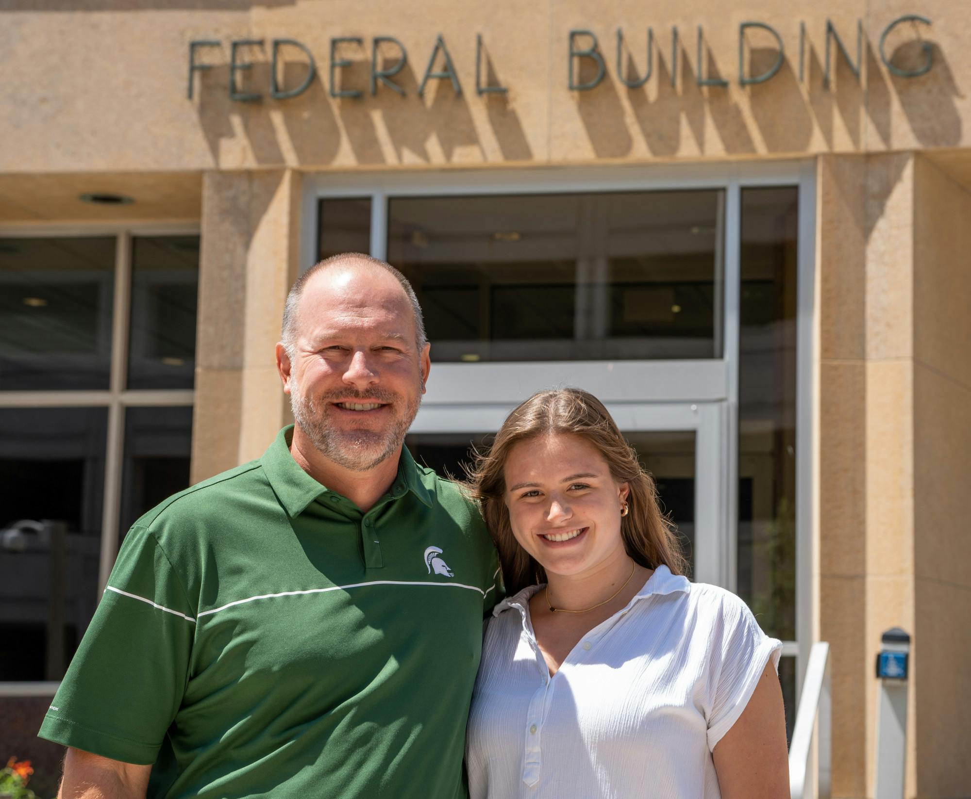 <p>Mike and Sophia Balow pose for a portrait outside of the Federal Building in Lansing on July 21, 2022.</p>