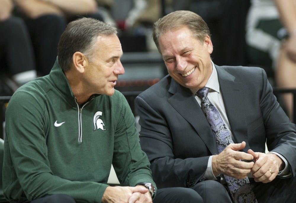 Head football coach Mark Dantonio chats with head basketball coach Tom Izzo before the start of the men's basketball game against Louisville on Dec. 2, 2015 at the Breslin Center. The Spartans defeated the Cardinals, 71-67. 