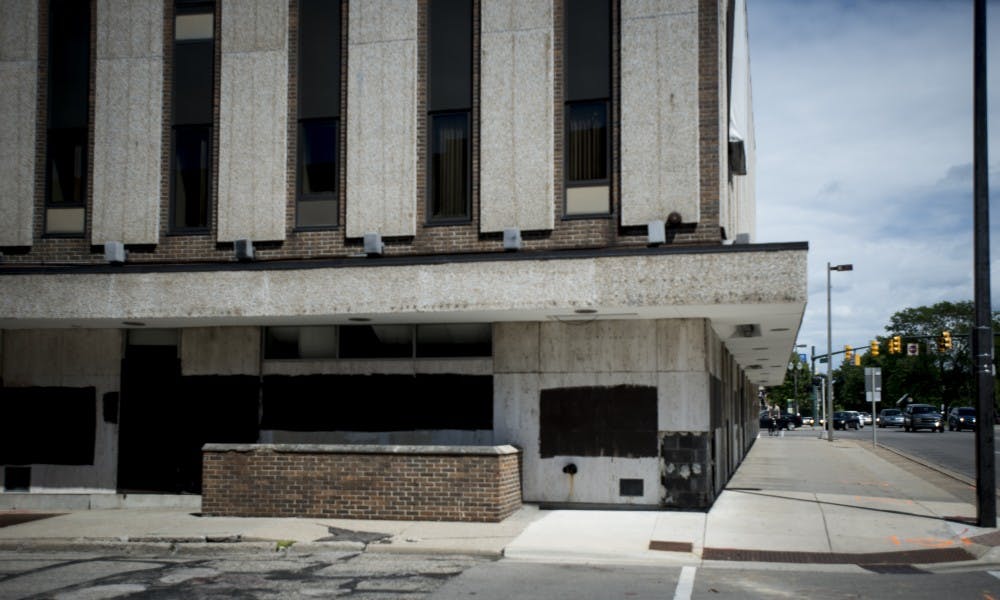 <p>An empty building is pictured at the corner of Grand River Avenue and Abbot Road on June 6, 2017. The building has since been demolished, and the remaining site is part of the Park District redevelopment project.</p>