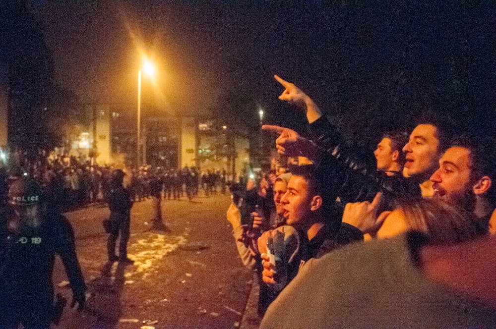 Students yell at the police officers after MSU's victory over Iowa on Dec. 5th, 2015, at Cedar Street celebration.