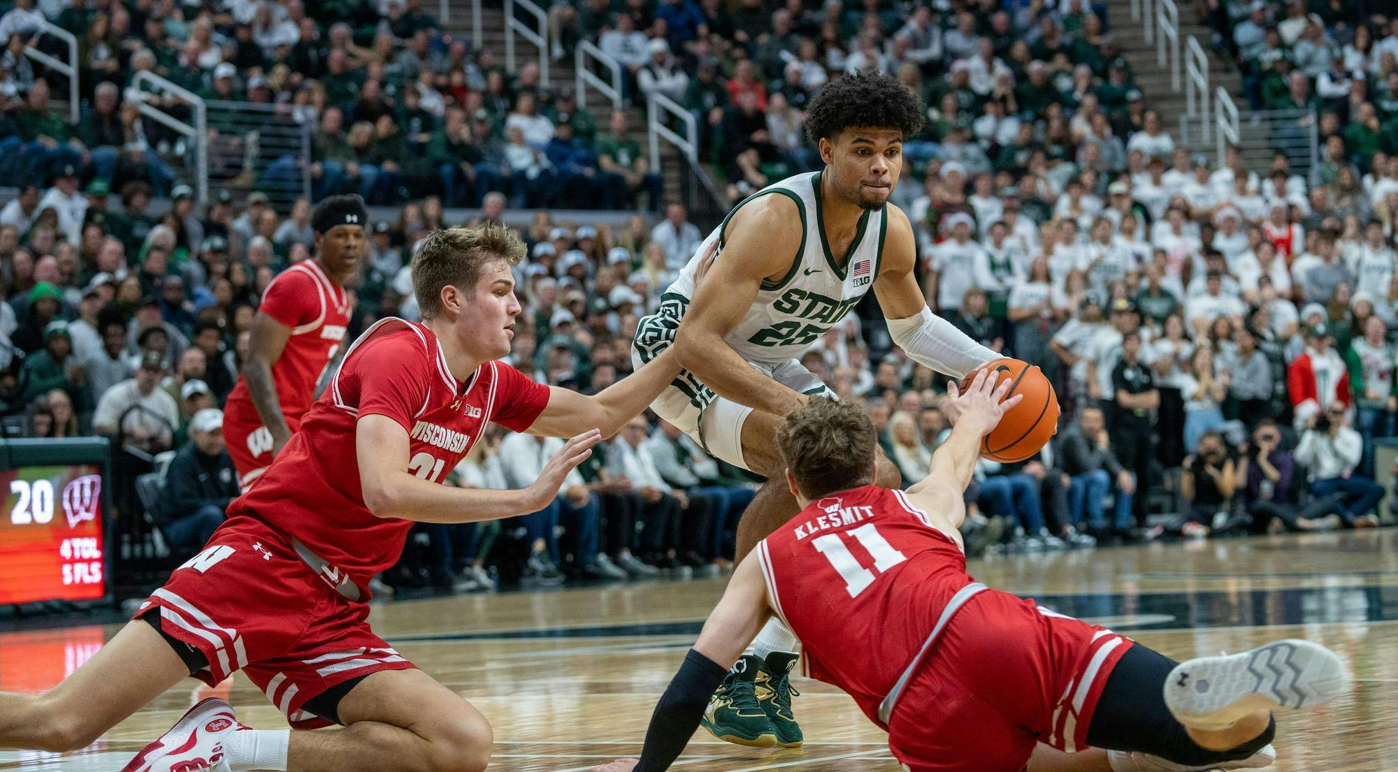 MSU Graduate Student Forward Malik Hall (25) protects the ball from Wisconsin players during the matchup at the Breslin Center on Dec. 5, 2023. MSU would go on to lose 57-70 against 23 Wisconsin.
