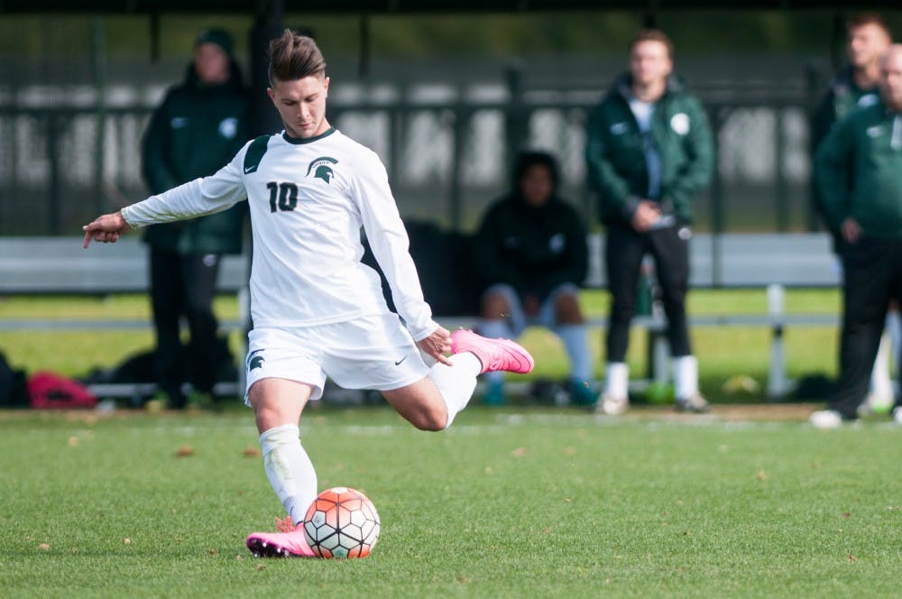<p>Senior midfielder Jason Stacy kicks the ball during the Men's Soccer game against Penn State on Oct. 18, 2015 at the DeMartin Soccer Complex. The Spartans defeated the Nittany Lions, 2-1. </p>