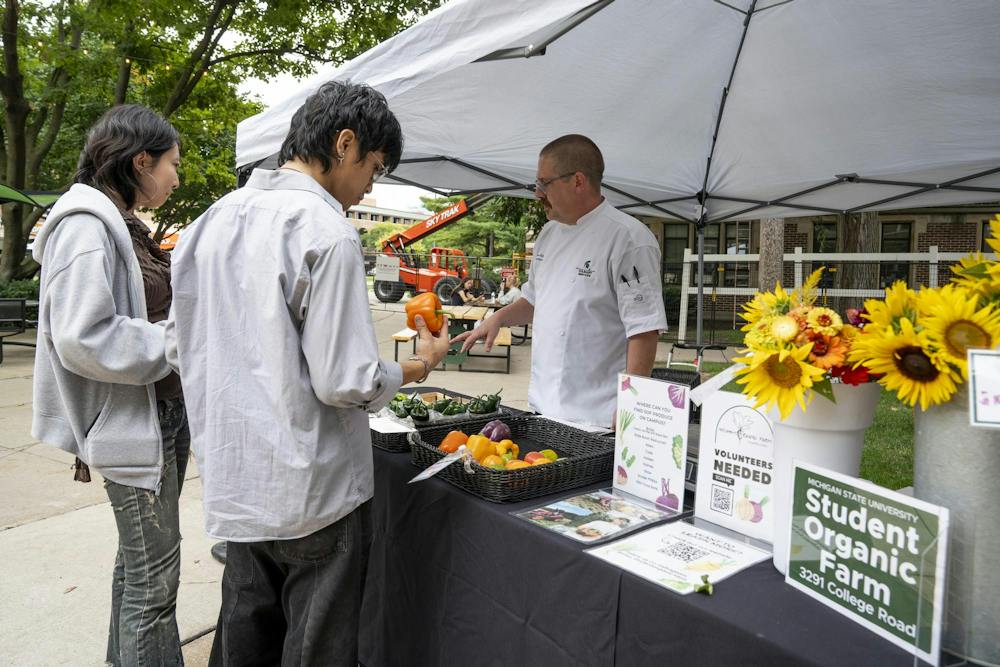 <p>MSU Culinary Services Senior Executive Chef of Residential Dining Bryan Latz talks with MSU students about the fresh produce grown at the Student Organic Farm in the MSU Union courtyard in East Lansing, Mich., on Wednesday, Sept. 16, 2026.</p>