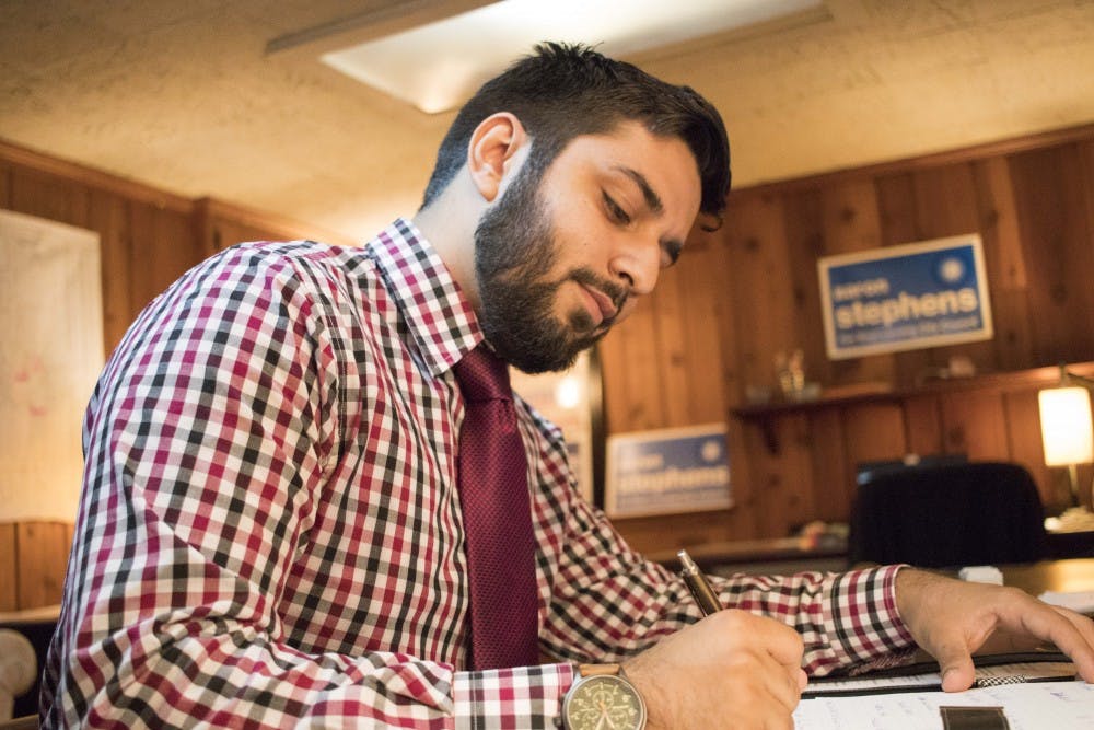 <p>Aaron Stephens writes some notes on Sept. 13, at his house on Kedzie Street. Stephens is running for East Lansing City Council.</p>