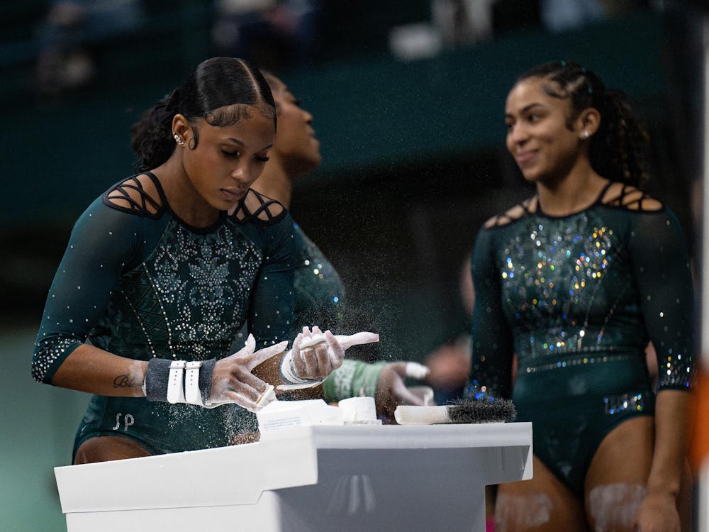 Nikki Smith, senior, prepares for the uneven bars during the MSU tri-meet at Jenison Field House on Sunday, Feb. 15, 2026.