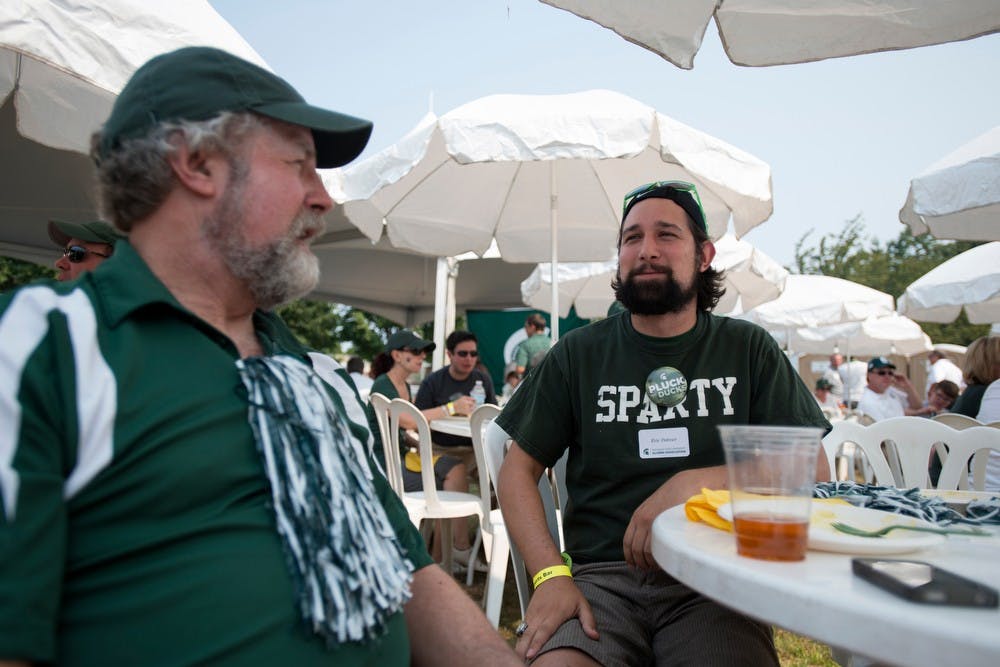 <p>Former Sparty Eric Palmer talks with his dad, Chuck Palmer, while tailgating before the Oregon vs. Michigan State game on Sept. 6, 2014, by Autzen Stadium at the University of Oregon in Eugene, Ore. Julia Nagy/The State News</p>