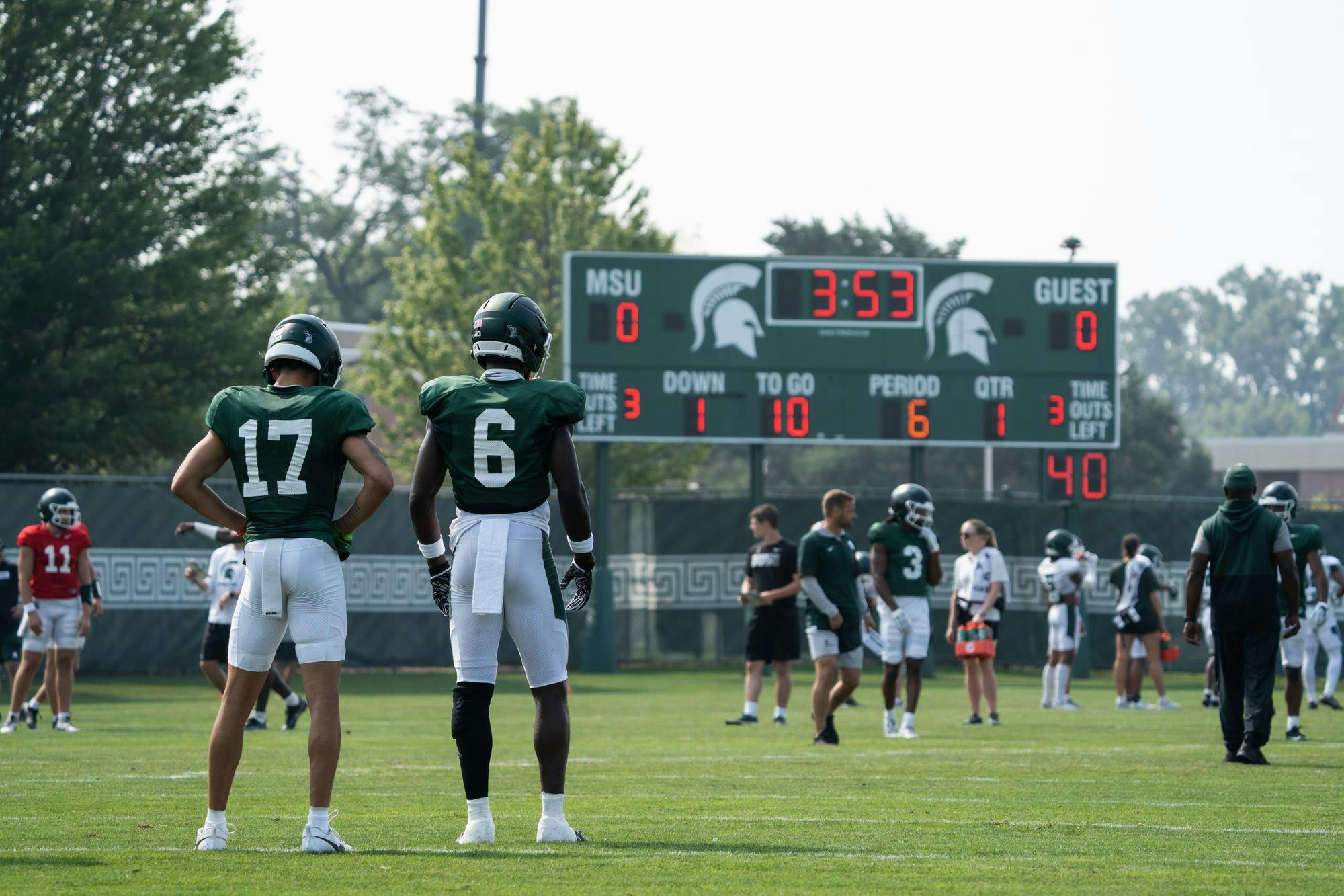 <p>Freshman wide receiver Braylon Collier (left) and sophomore wide receiver Nick Marsh (right) watch during summer training camp on the practice fields outside the Duffy Daugherty Football Building on August 5, 2025.</p>