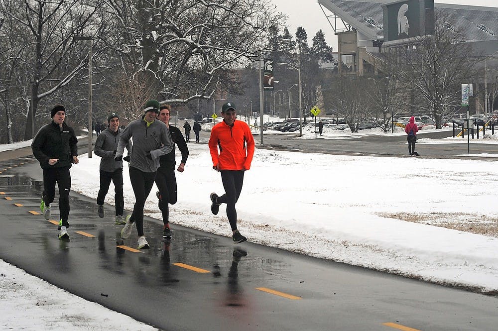 <p>Members of the cross country and distance track teams run The River Trail Jan 29, 2015, during their baseline workout.</p>