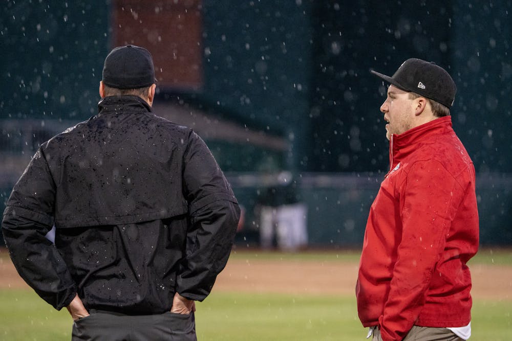 <p>A Lansing Lugnuts groundskeeper confers with an official during the Crosstown Showdown at Jackson Field as the rain continues on April 4, 2023.</p>