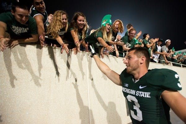 <p>Then-junior punter Mike Sadler high-fives fans after the against Western Michigan on Aug. 30, 2013, at Spartan Stadium. The Spartans defeated the Broncos, 26-13.</p>