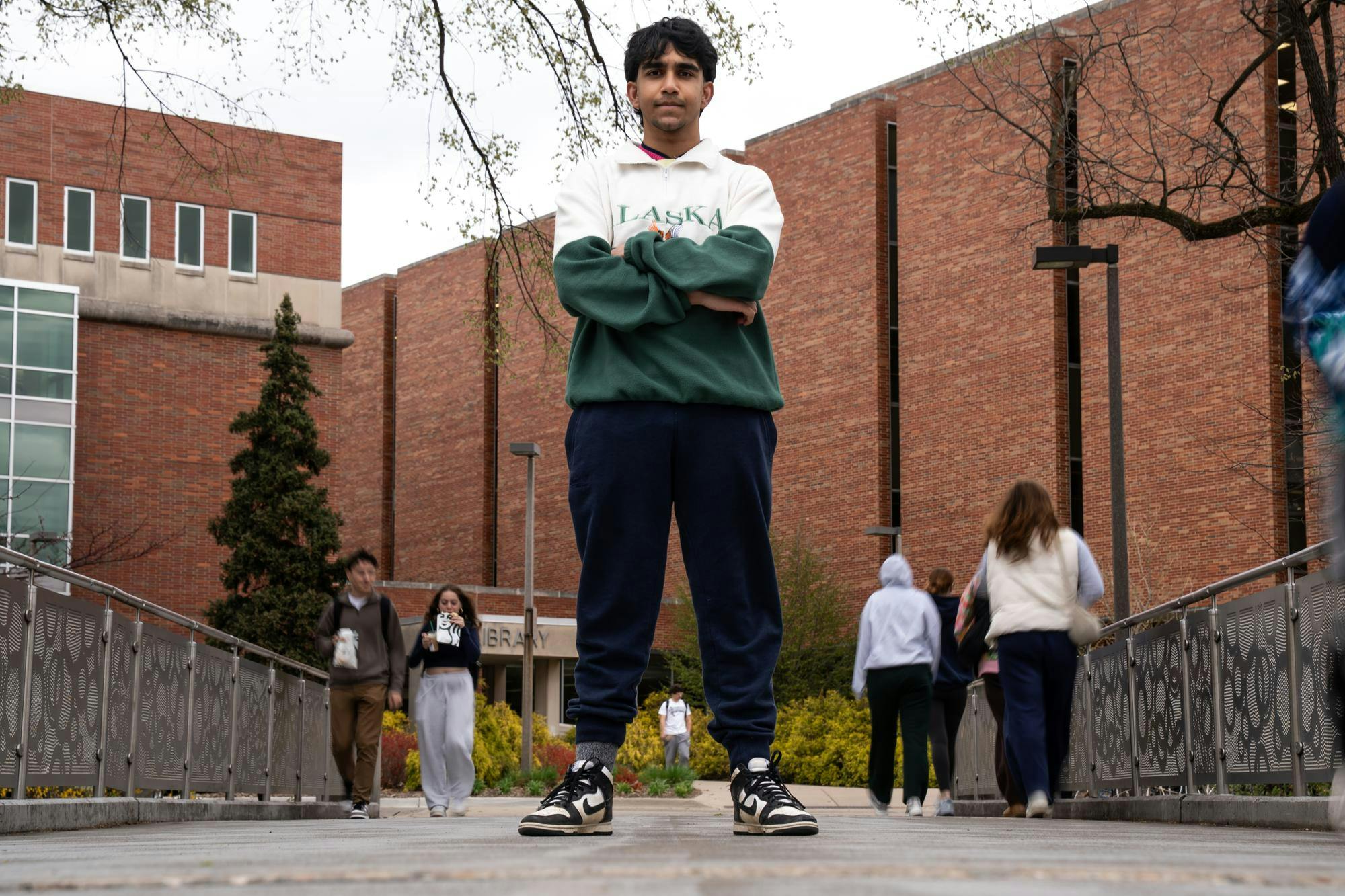 Satvik Shubham, the sports desk editor at The State News and international student, stands on a pedestrian bridge over the Red Cedar River on April 21, 2025.