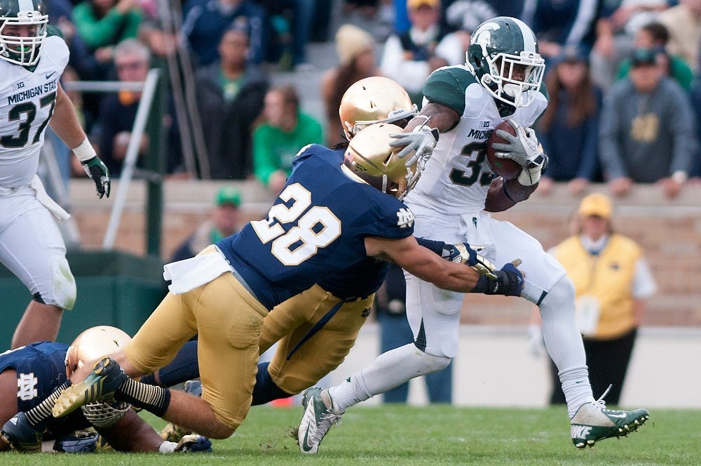 <p>Junior running back Jeremy Langford pushes away senior safety Austin Collinsworth during the game against Notre Dame Sept. 21, 2013, at Notre Dame Stadium in South Bend, Ind. The Fighting Irish defeated the Spartans 17-13. Julia Nagy/The State News</p>