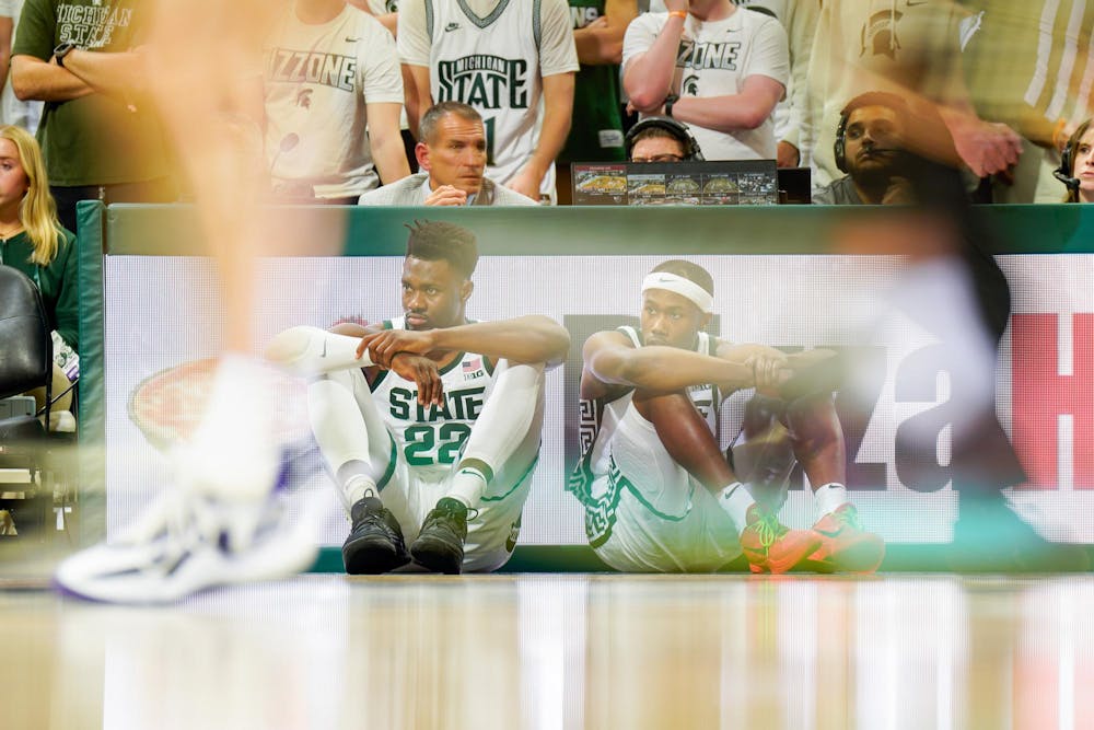 <p>Senior center Mady Sissoko and sophomore guard Tre Holloman wait to check in during a match against Northwestern University at the Breslin Center on March 6, 2024.</p>