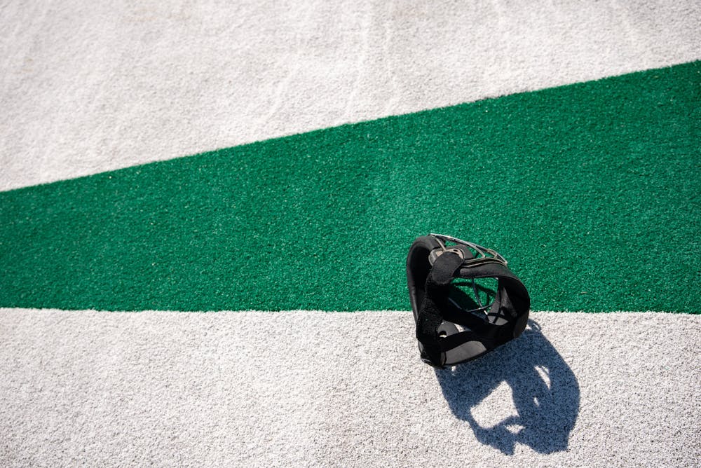 An MSU player's face mask is tossed behind the goal after a penalty corner during a game against Michigan on April 2, 2021.