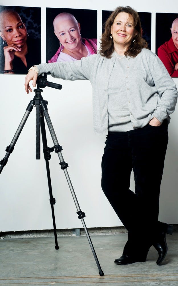 East Lansing based photographer Terri Shaver stands in front of portraits she has shot as part of her ?Be Bold, Feel Beautiful? campaign. The campaign, ran by the Oldham Project, provides professional portraits those living with a terminal illness free of charge. Matt Hallowell/The State News