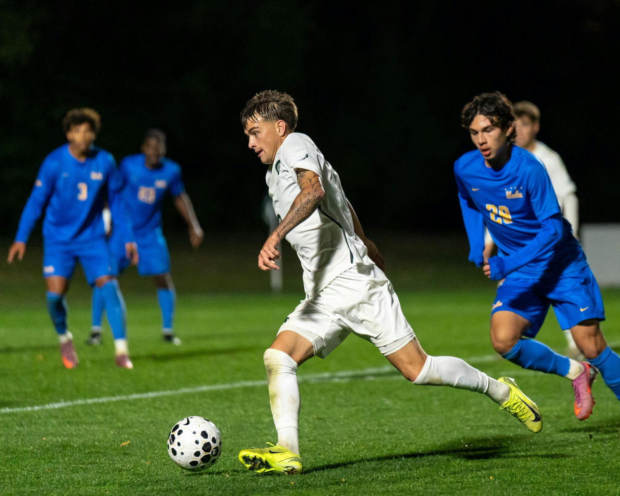 MSU M Jr. Miles Merritt (8) dribbles the ball past UCLA defenders in DeMartin Soccer Stadium in East Lansing, MI on Oct. 20, 2025.
