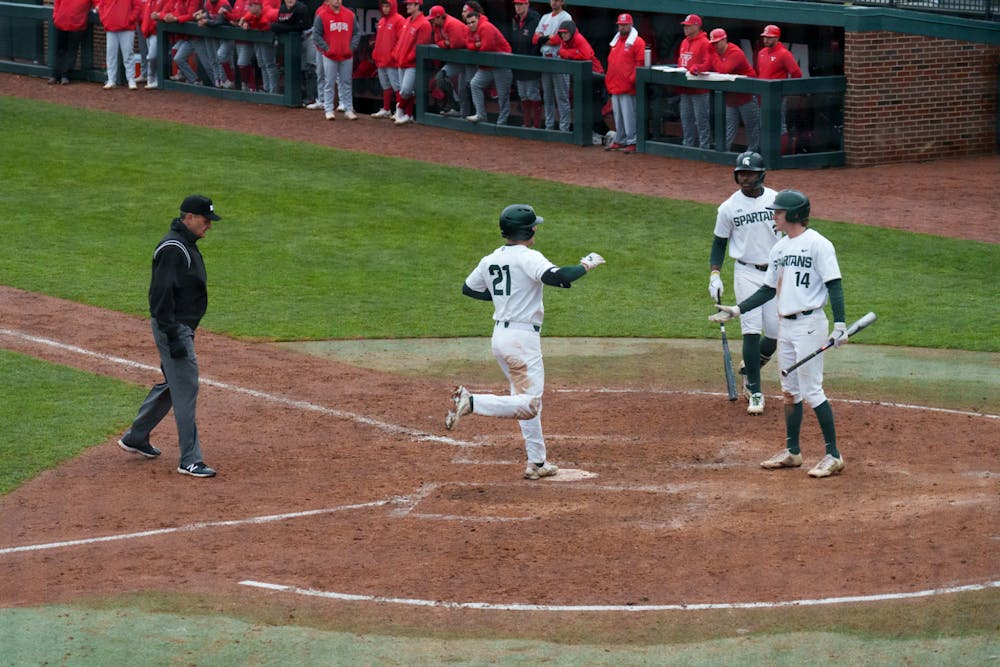 <p>Michigan State sophomore Jack Frank celebrates with sophomore Mitch Jebb and junior Zaid Walker after they all had finished their runs on March 30, 2022. Spartans are victorious 12-5 against Youngtown State.</p>