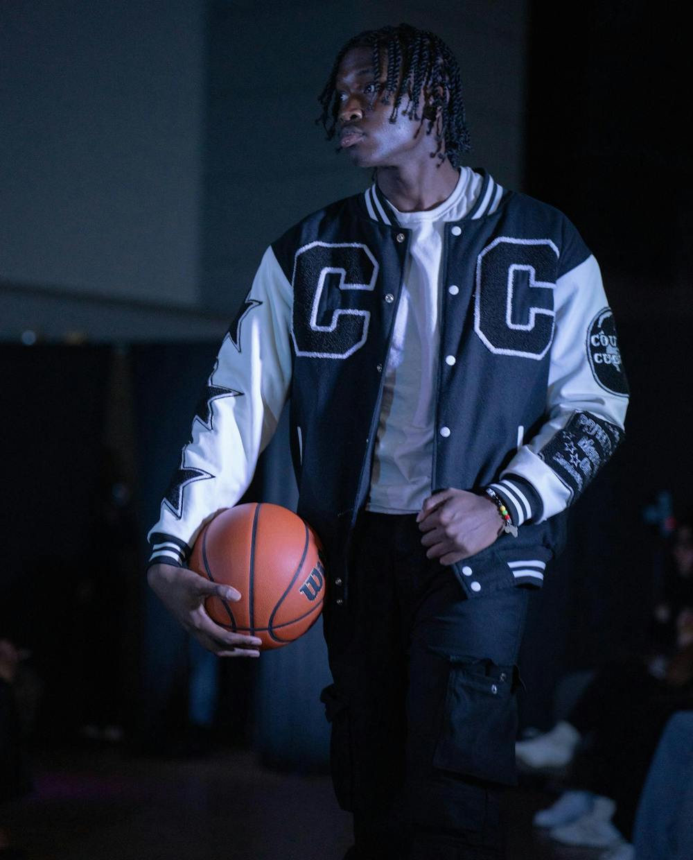 <p>A model poses in a varsity jacket designed by Coutur3 Culture, owned by apparel and textile design senior, Damond Hardwick.</p>