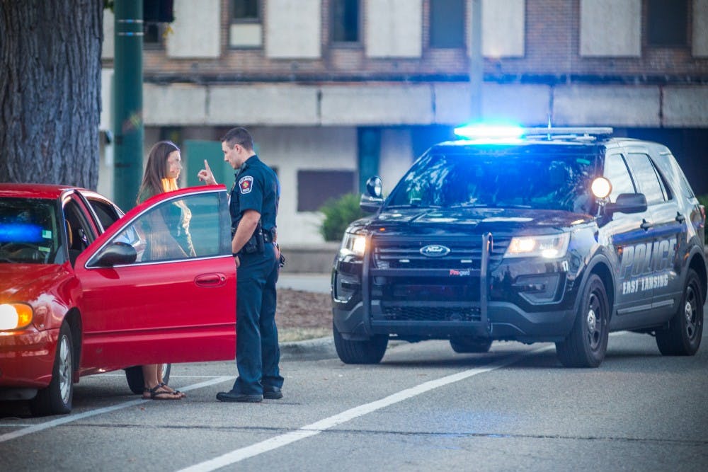An East Lansing police officer conducts a field sobriety test on Sep. 2, 2017, outside of Campbell Hall on Abbot road.