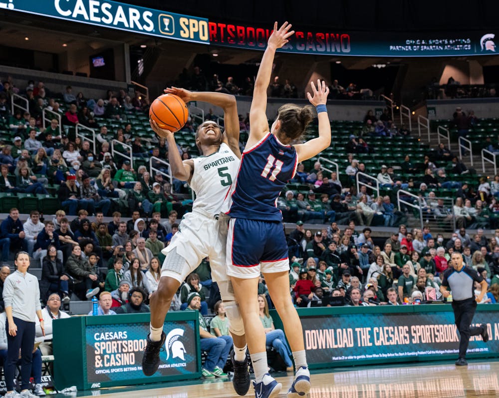 Detroit Mercy's Ana Cabañas Llorens (11) attempts to block a shot attempt by Michigan State's Kamaria McDaniel (5). The Spartans defeated Detroit Mercy 91-41 in the Breslin Student Events Center on Dec. 18, 2022.