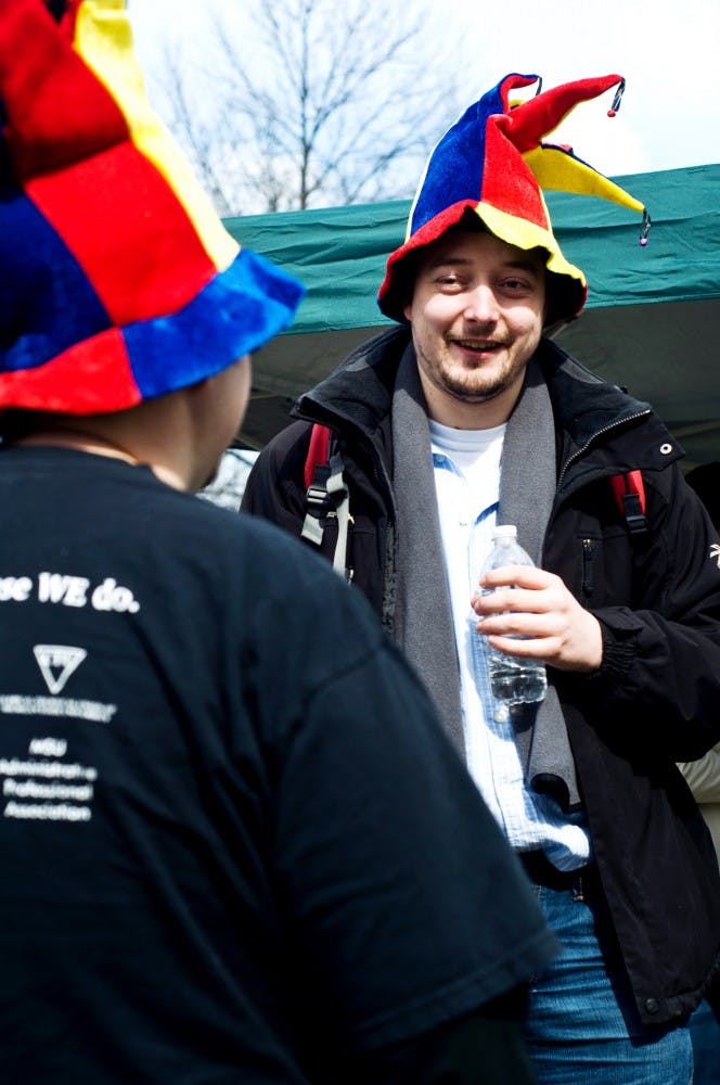 Math graduate student Jochen Vermeulen, right, talks with English Literature graduate student Neal Klomp Friday afternoon at the "We Aren't Fooling Bargaining Tailgate." The tailgate was held by The Graduate Employees and was meant to bring attention to the groups dissatisfaction with the way bargaining over contracts has been going. Matt Hallowell/The State News