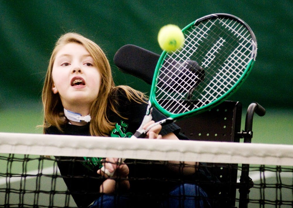 Katie Frayer, 15, of DeWitt Mich., hits the ball Wednesday evening at the MSU Tennis Center, 3571 East Mount Hope Avenue in Lansing. Each Wednesday, men's tennis coach Gene Orlando teaches tennis to people in wheelchairs from six to eight p.m. Samantha Radecki/The State News